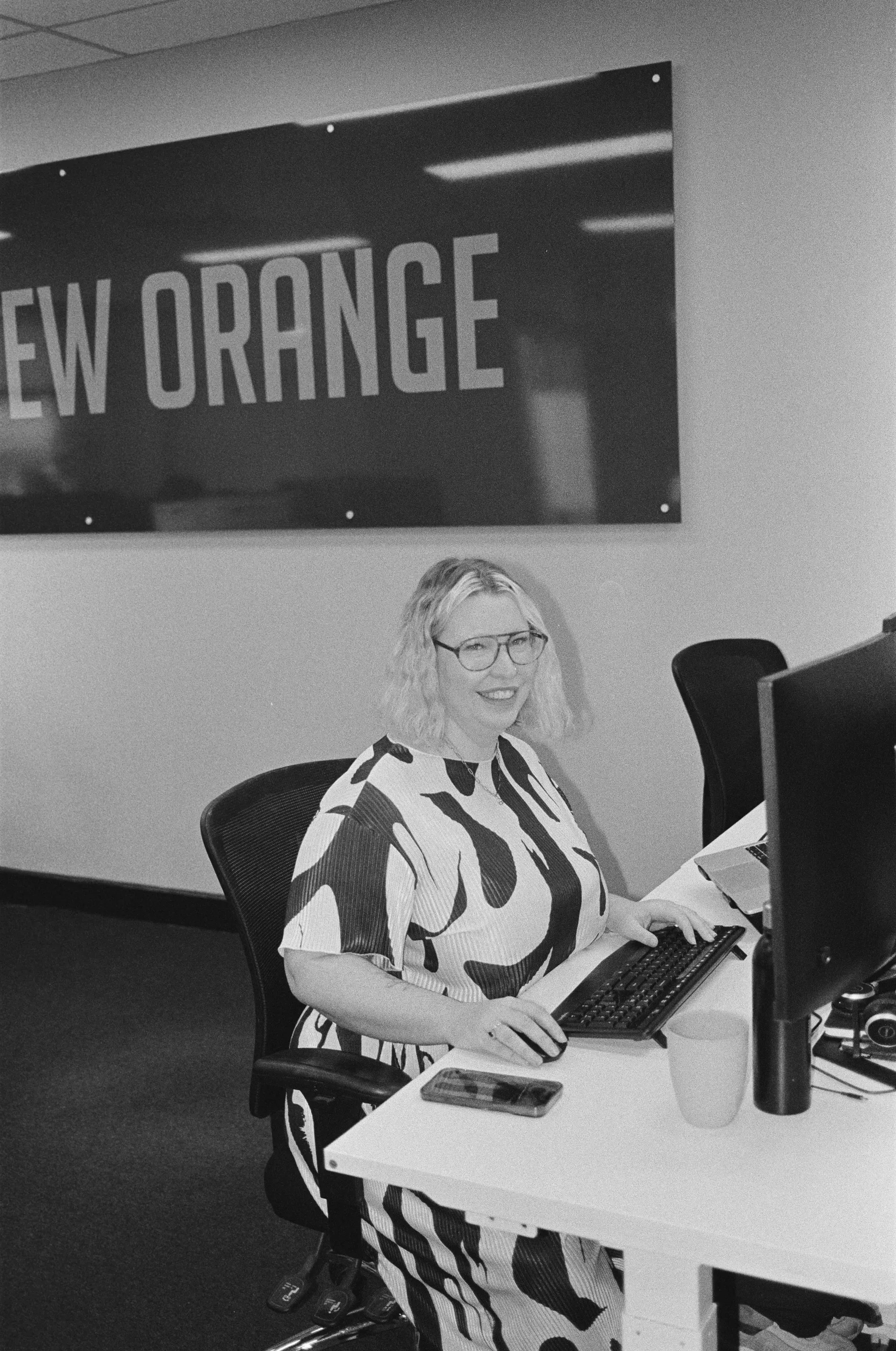 Colleagues smiling behind desks