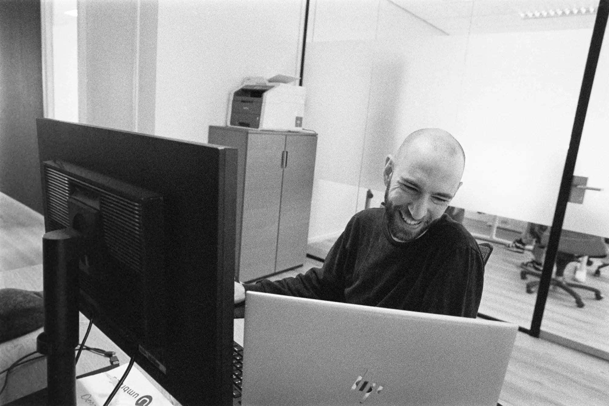 Dennis Pullens lachend aan zijn bureau