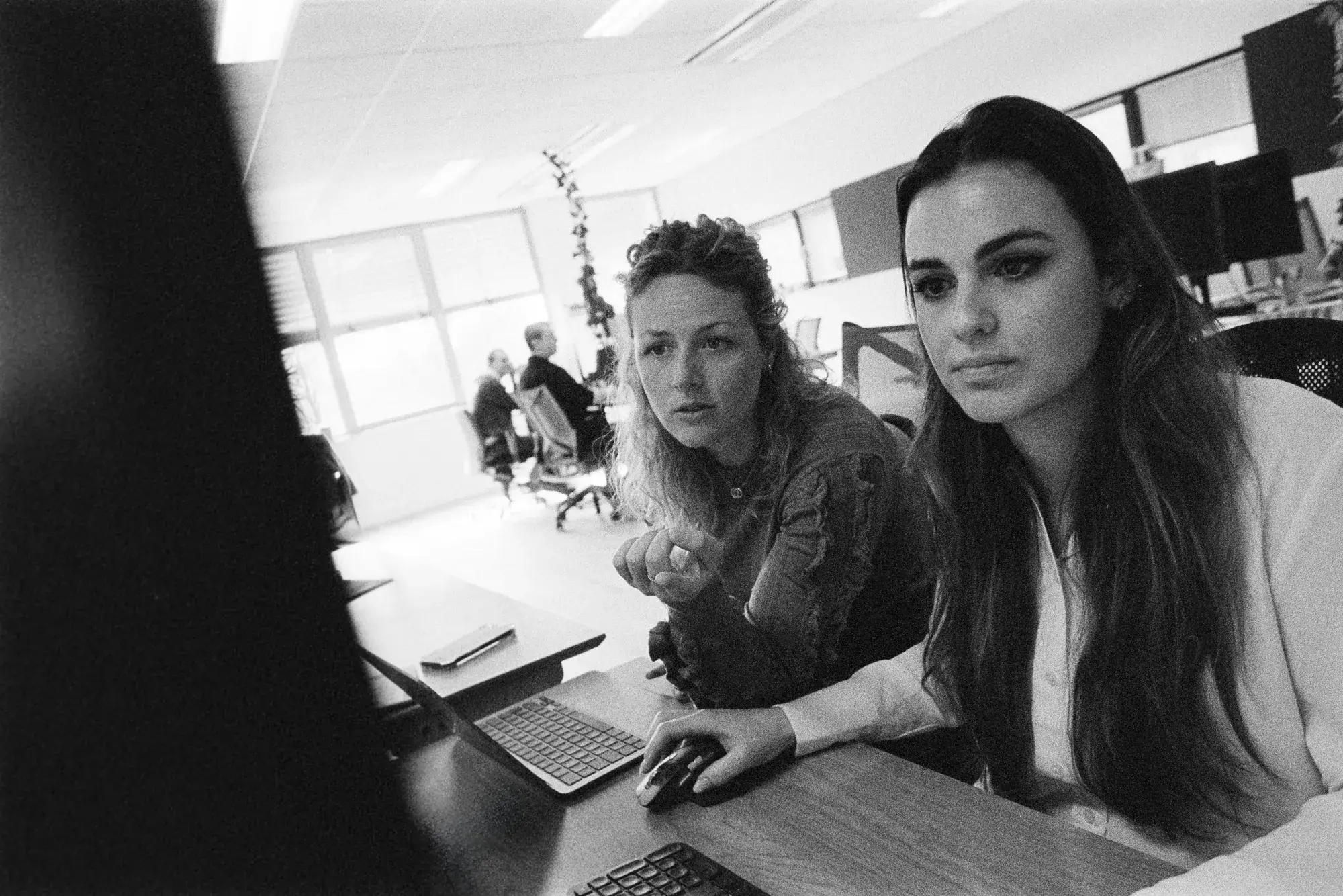 Two colleagues looking at a computer screen together