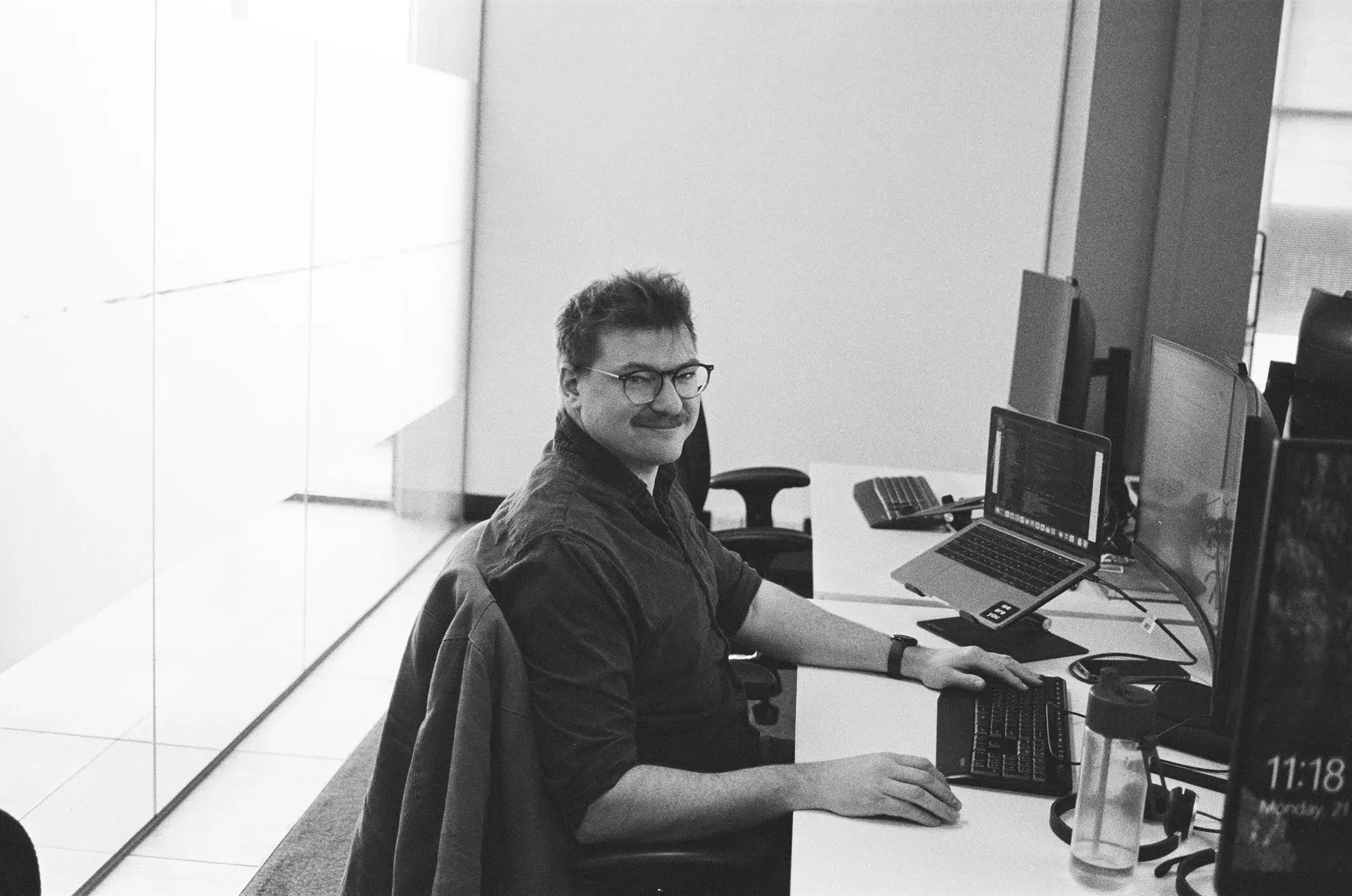 A colleague is sitting at their desk with a smile