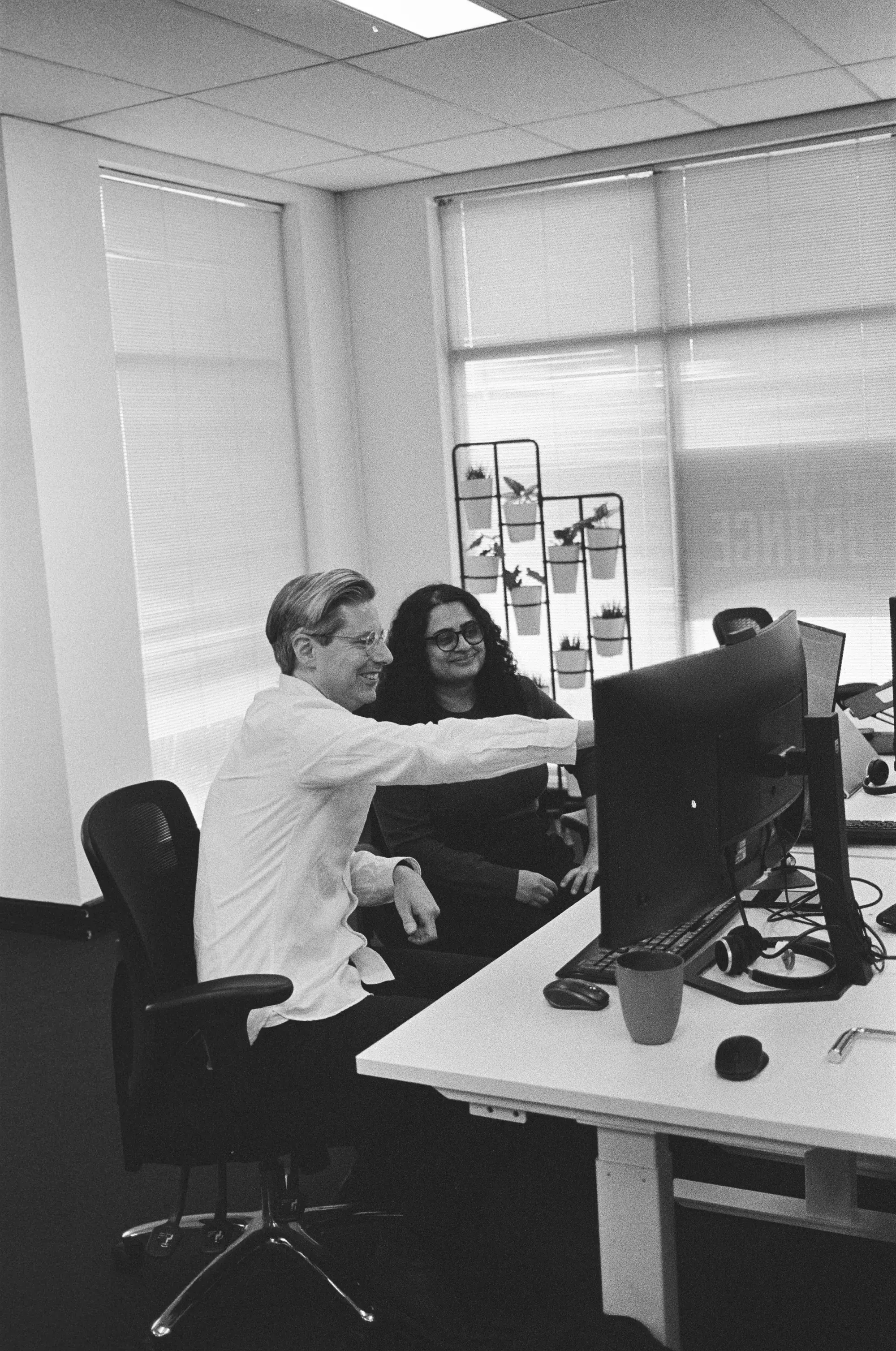 Two colleagues working together behind a desk