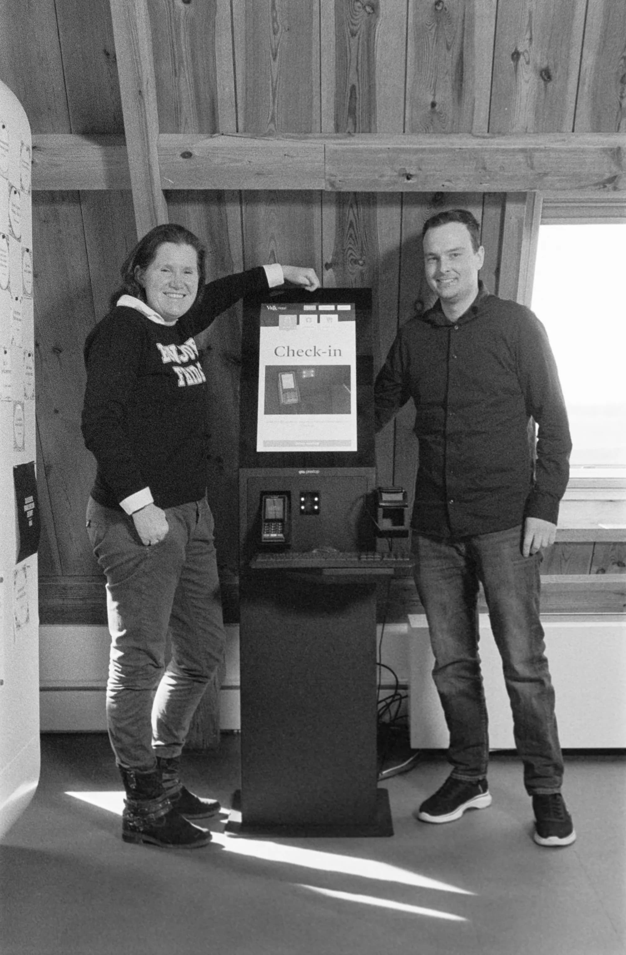 Twee collega's staan bij een incheck-zuil